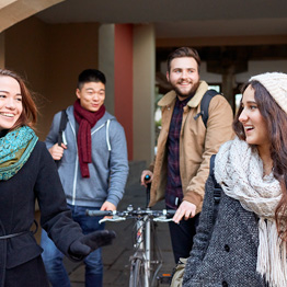 Smiling students walking under archway
